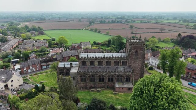 The stunning St Oswald&rsquo;s Church and surrounding Malpas - drone rotate from near, revealing village, Cheshire, UK