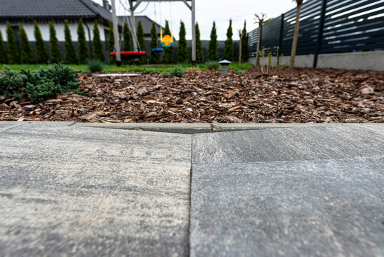 Uneven paving slabs showing ground subsidence in yard