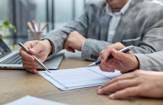 Two professionals review documents at a polished desk
