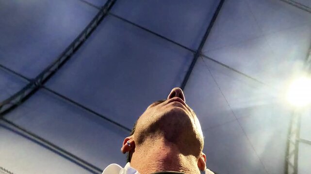 Close-up of a male player seen from below during a break during a match. The video was shot inside an indoor sports facility