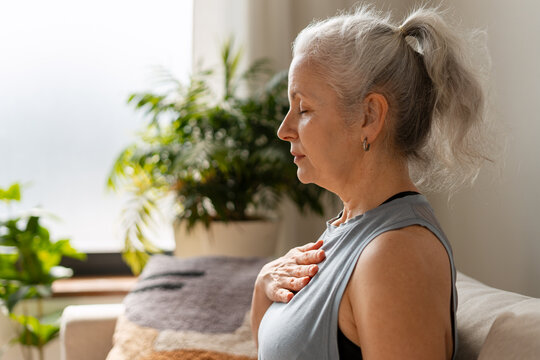 Senior woman practicing mindfulness and deep breathing at home