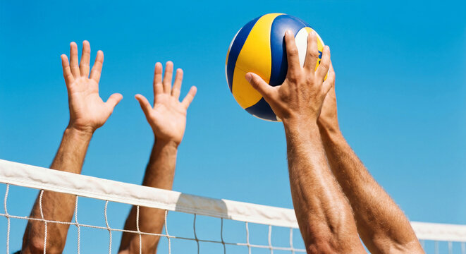 Action shot of a volleyball player spiking the ball over a net against a clear blue sky during a competitive match