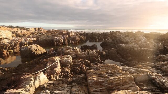 sunset light over rocky coastline of DeKelders, Gansbaai, South Africa