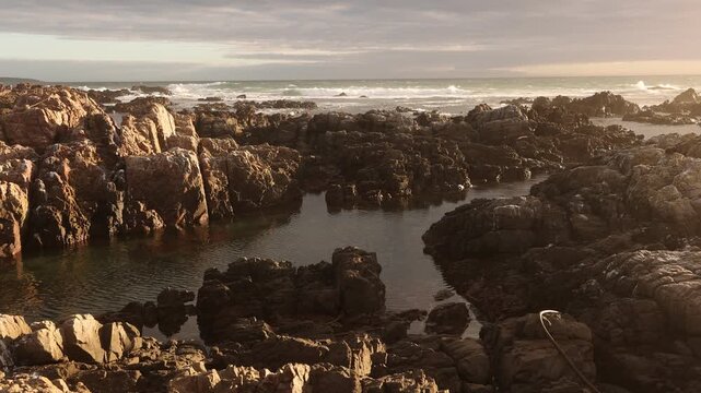 sunset light over rocky coastline of DeKelders, Gansbaai, South Africa