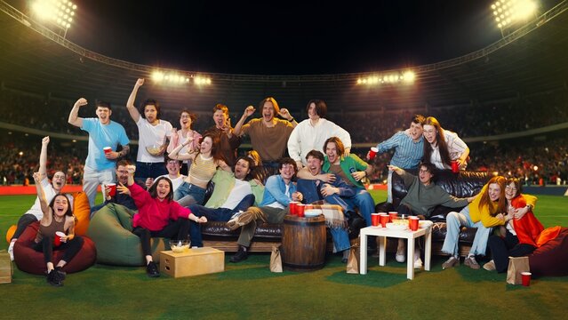 Large group of young fans celebrating victory in bright stadium arena. Concept of match day excitement, live broadcast, fan culture, group leisure and sports promo.