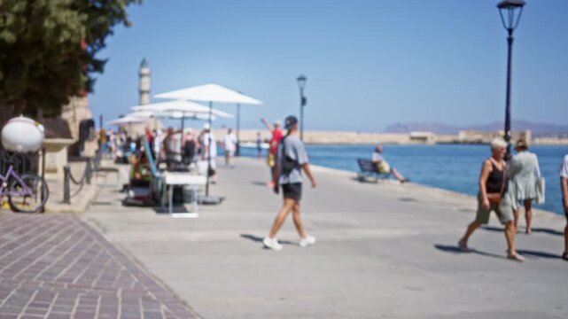 Blurred seaside promenade in chania crete with soft bokeh, umbrellas and lampposts in shallow street; background backplate copyspace calm.