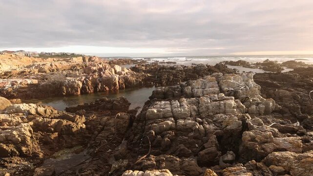 sunset light over rocky coastline of DeKelders, Gansbaai, South Africa