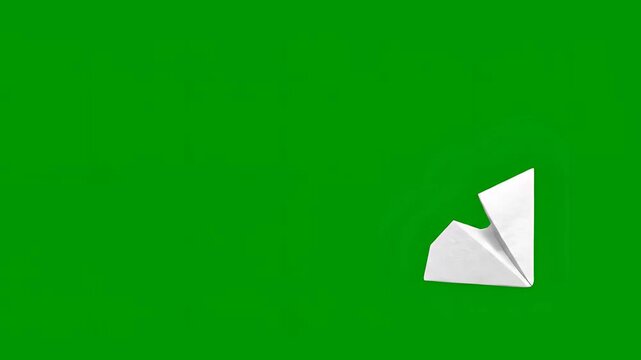 White paper airplane flying across a vibrant green background.