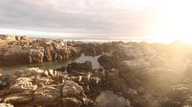 sunset light over rocky coastline of DeKelders, Gansbaai, South Africa