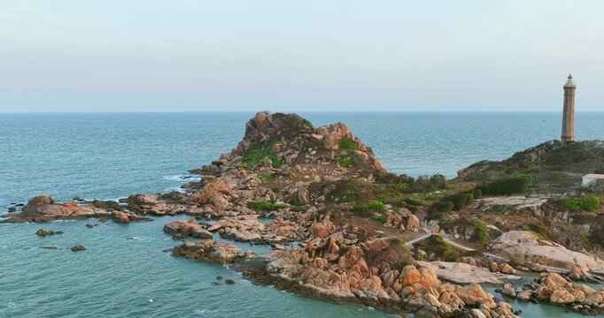 Spectacular sunset over Ke Ga Lighthouse in Binh Thuan, Vietnam. Aerial drone view captures the historic lighthouse standing among dramatic rocky formations