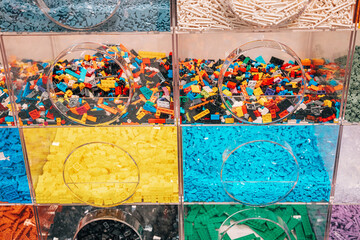 Fototapeta premium 19 October 2025, Belgrade, Serbia: Various colorful LEGO bricks sorting in plastic bins on a pick a brick wall creating a vibrant toy store display