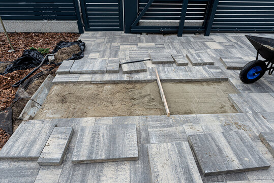 Paving work in progress, laying concrete slabs on a sand bed