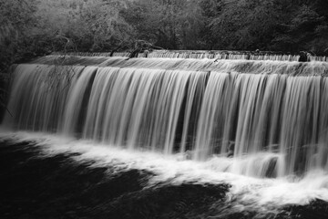 Black and white long exposure of a cascading waterfall in nature © Mathias