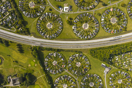 Aerial view of Haveforeningen Harekaer circular garden community with unique circular housing layouts and green hedges under bright sunlight in Brondby, Denmark.