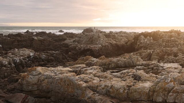 sunset light over rocky coastline of DeKelders, Gansbaai, South Africa