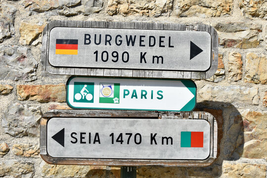 Road Signs for Cars and Bicycles to Faraway Destinations on European Continent in Domfront, Normandy