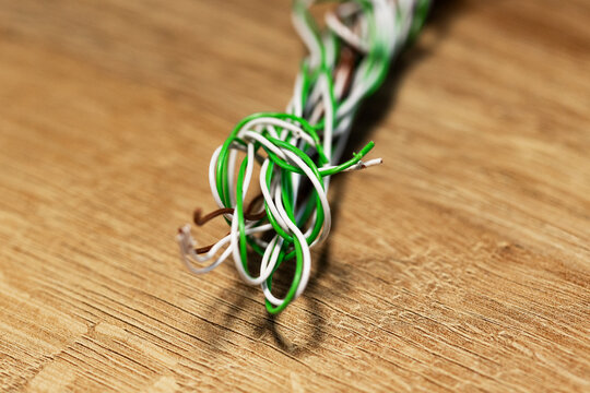 Close-up coverd knotted and intertwined wires of different colors on the table. Electricity wire, cable, energy, electric curent,