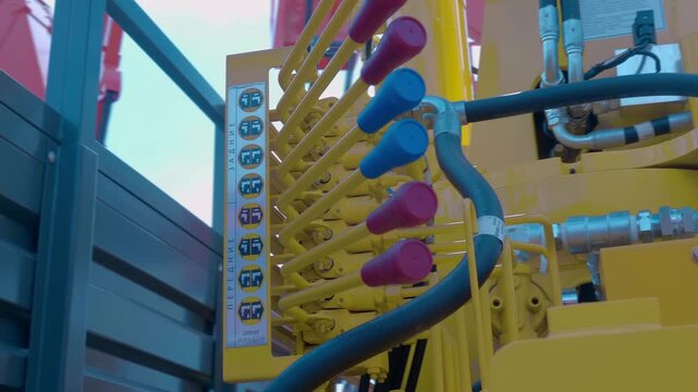 Hydraulic control unit with multiple levers on a truck lift at an exhibition. Shot in motion