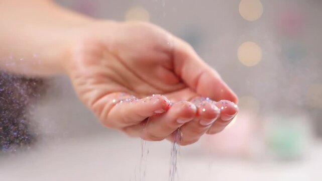 Hand with glitter sparkles in soft dreamy light