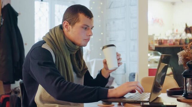 Caucasian man multitasking in cafe laptop coffee, checking notebook while sipping takeaway cup, answering phone and scanning documents, deadlinedriven posture, modern interior, focused expression,