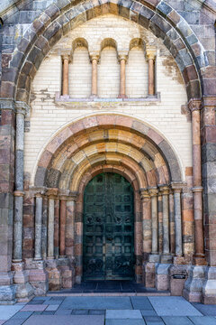 View of the ornate Romanesque portal of Ribe Cathedral with its green bronze door and multi-colored stone arches in Ribe, Denmark.
