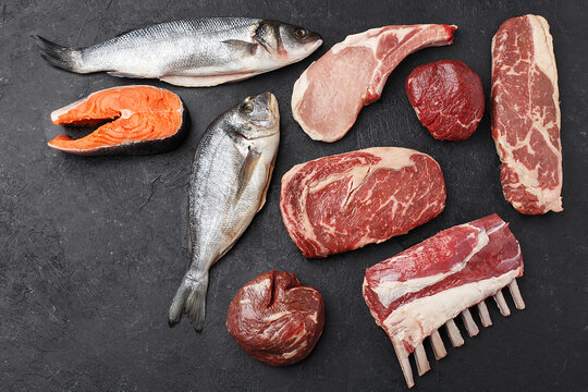 Selection of various type of raw meat and fish - sea bass fish, dorado fish, trout or salmon steak, pork loin, filet mignon, filet chateau, striploin steak, ribeye steak and rack of lamb. Top view