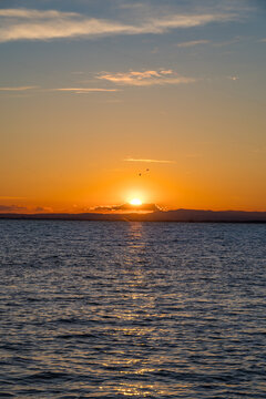 Golden Sunset Over Sea With Mountain Silhouette and Sunpath Reflection on Water