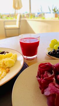 Rich all inclusive breakfast with mango juice, fresh strawberry, salmon and basturma meat on luxury 5-star hotel terrace in Sharm El Sheikh. Lavish chic food styling at resort buffet in Egypt.