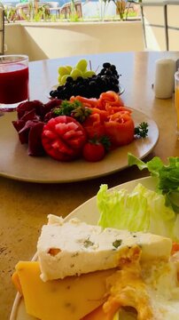 Rich all inclusive breakfast with mango juice, fresh strawberry, salmon and basturma meat on luxury 5-star hotel terrace in Sharm El Sheikh. Lavish chic food styling at resort buffet in Egypt.