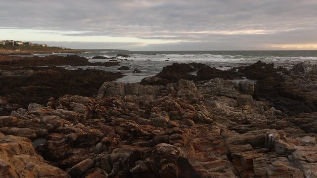 sunset light over rocky coastline of DeKelders, Gansbaai, South Africa