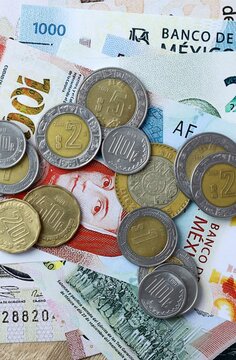 Mexican peso money bills and coins on table. Mexico cash of MXN currency close up