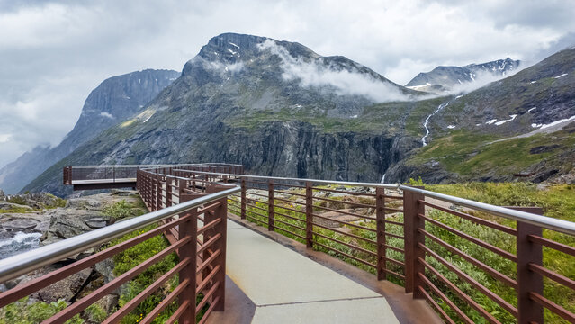 View of the Trollstigen viewpoint platform overlooking dramatic mountain peaks and misty valleys Andalsnes, More og Romsdal, Norway.