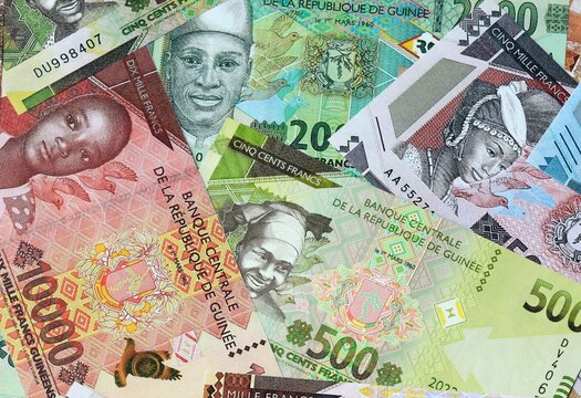Guinean franc money banknotes bunch on table. Guinea bills of GNF currency close up