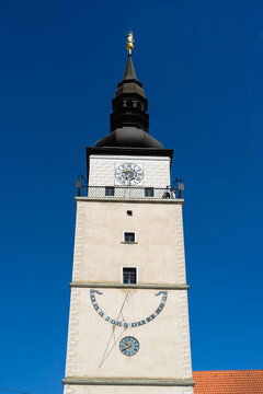 View of the historic City Tower featuring a clock face and sundial under a clear blue sky in Trnava, Trnava Region, Slovakia.