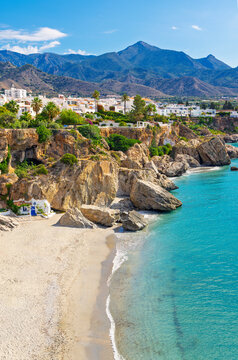 vertical view of calahonda beach and white village of nerja in andalusia, spain, turquoise water and mountains background. Malaga province