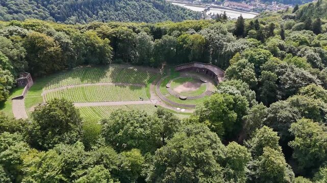 Drone view of Thingstatte Heidelberg open air amphitheater with stone seating surrounded by dense forest on Heiligenberg, Germany.
