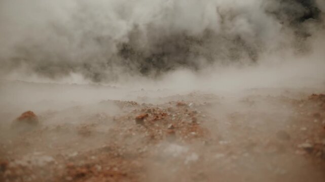 Volcano's crater is filled with dense lava plug and clouds of steam and smoke emerge from cracks and creep along edges in gusts of wind.