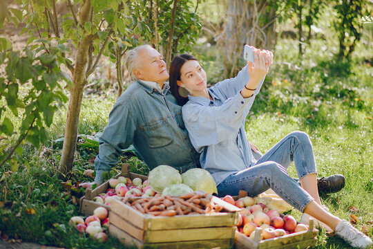Old senior standing in a summer garden with harvest