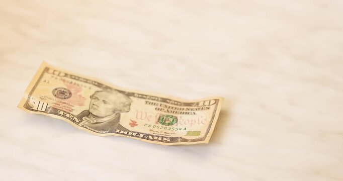 Suitable shot when a person examines a brown wallet while showing only a ten-dollar bill during his low financial lifestyle.