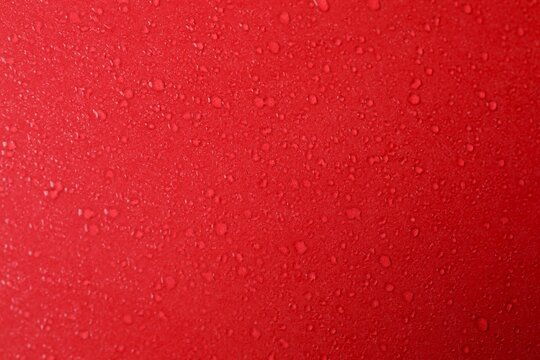 Top view photo of water drops on red background