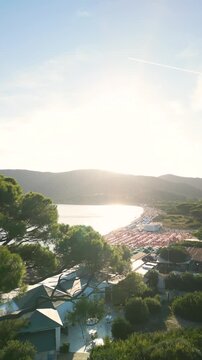 Drone Reveal Shot from Trees Over Lacona Beach with Colorful Umbrellas &ndash; Spiaggia di Lacona, Elba Island, Italy