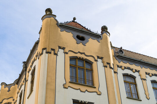View of the Art Nouveau facade of the Gamca gymnasium with decorative yellow walls and grey ornaments under a clear sky in Bratislava, Bratislava Region, Slovakia.