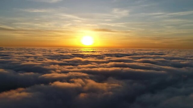 Golden sunrise above endless sea of clouds aerial footage