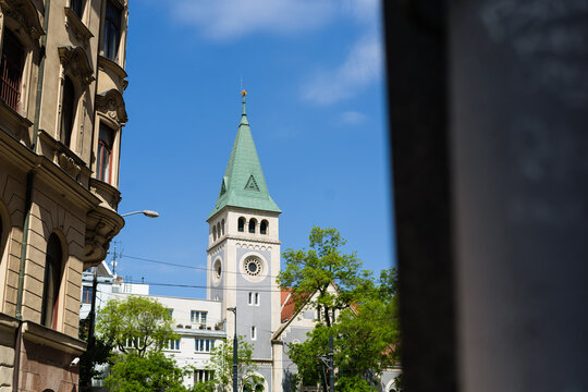 View of the Reformed Church tower with its distinctive green spire and historic facade under a clear blue sky in Bratislava, Bratislava Region, Slovakia.