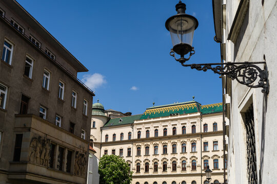 View of historic buildings with ornate facades and a traditional street lamp under a clear blue sky in Bratislava, Bratislava Region, Slovakia.