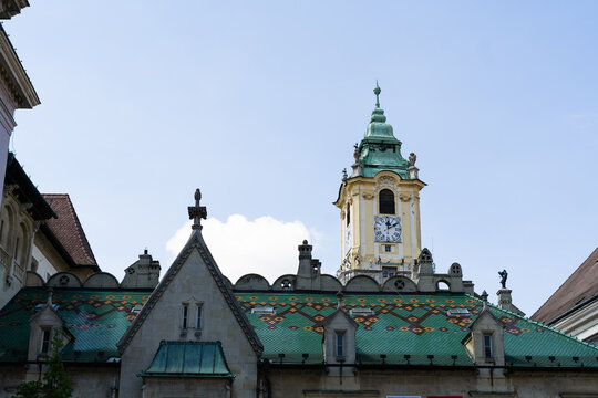 View of the Old Town Hall featuring its ornate clock tower and colorful patterned tiled roof under a clear sky in Bratislava, Bratislava Region, Slovakia.
