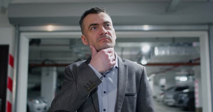 Serious businessman checks quality of newly completed construction. Attentive man inspects parking area evaluating materials markings and structural precision