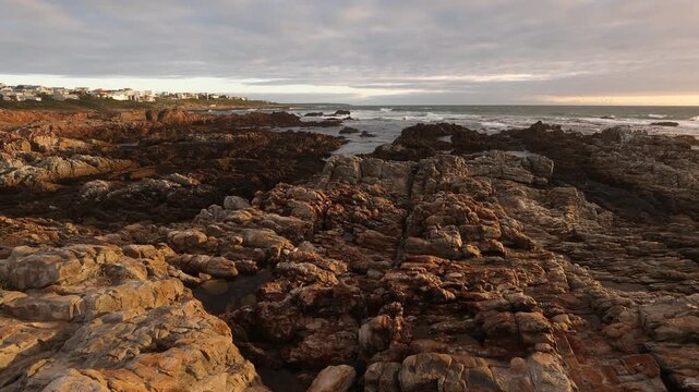 sunset light over rocky coastline of DeKelders, Gansbaai, South Africa