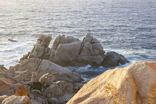 View of the unique granite rock formations overlooking the blue Mediterranean Sea during golden hour Capo Testa, Sardegna, Italy.