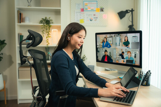 First jobber joins a virtual team meeting from home, typing meeting minutes and notes on her laptop and tablet, embracing hybrid work, digital tools, and building soft skills in flexible work culture